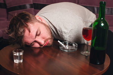 мужчина уснул возле алкоголя